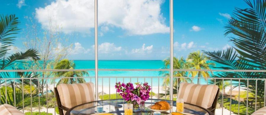 a dining room with a view of the ocean at The Tuscany on Grace Bay in Grace Bay