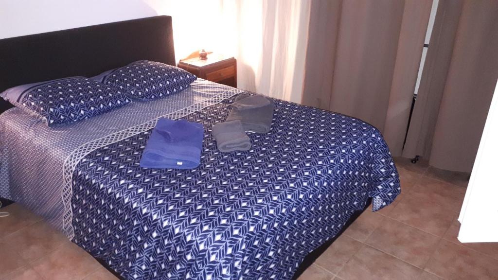 uma cama com um edredão azul e dois sacos em Maisonnette au pied de la garrigue em Bernis