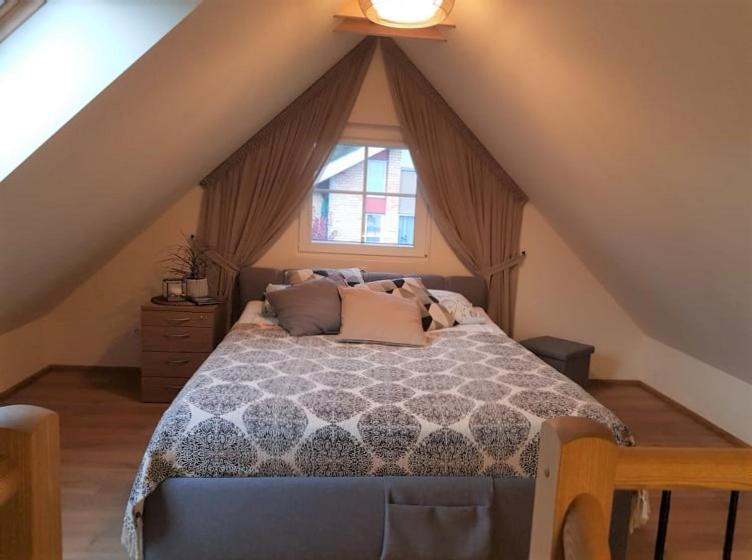 a bedroom with a large bed in a attic at "Pamario Namelis" - Preiloje in Neringa