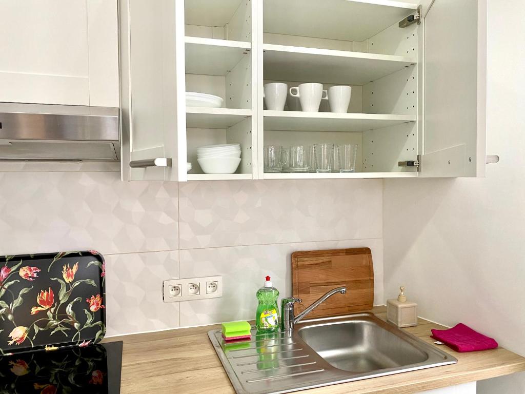 a kitchen with white cabinets and a sink at BONJOUR Apartments Сentre 3 in Antwerp