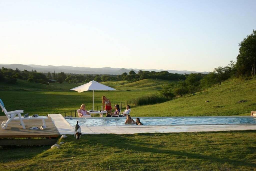 a group of people sitting in a swimming pool at La Deseada Casa de Campo in La Granja