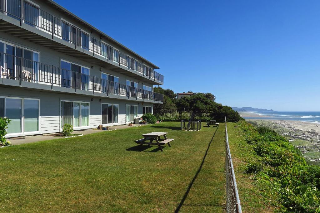 a building with a picnic table next to the ocean at Ocean Terrace Condominiums in Lincoln City