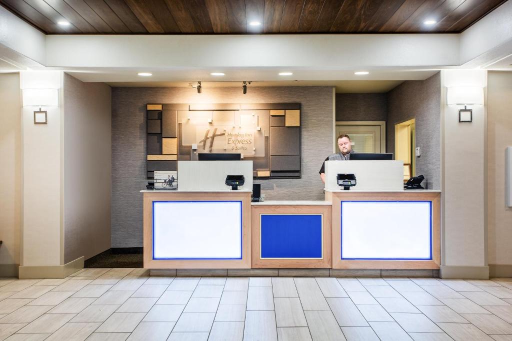 a man standing at a counter in a hotel lobby at Holiday Inn Express Hotel & Suites Lewisburg, an IHG Hotel in Lewisburg