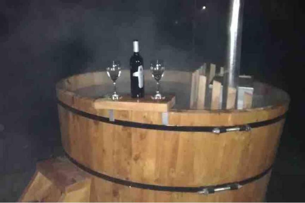 barril de madera con dos copas y una botella de vino en Cabaña Con Tinajas #2, en Quillón