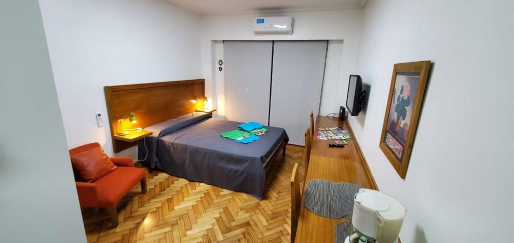 - une chambre avec un lit, une chaise et un canapé dans l'établissement BUENOS AIRES EXPERIENCE - Av Corrientes - Obelisco, à Buenos Aires