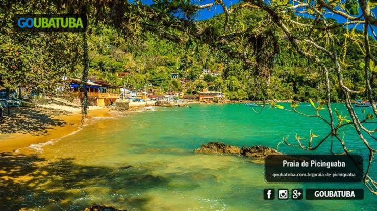 a view of a beach with blue water and trees at Casa de Praia Picinguaba in Ubatuba