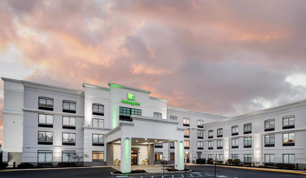 a white building with a green sign on it at Holiday Inn Allentown-Bethlehem by IHG in Allentown