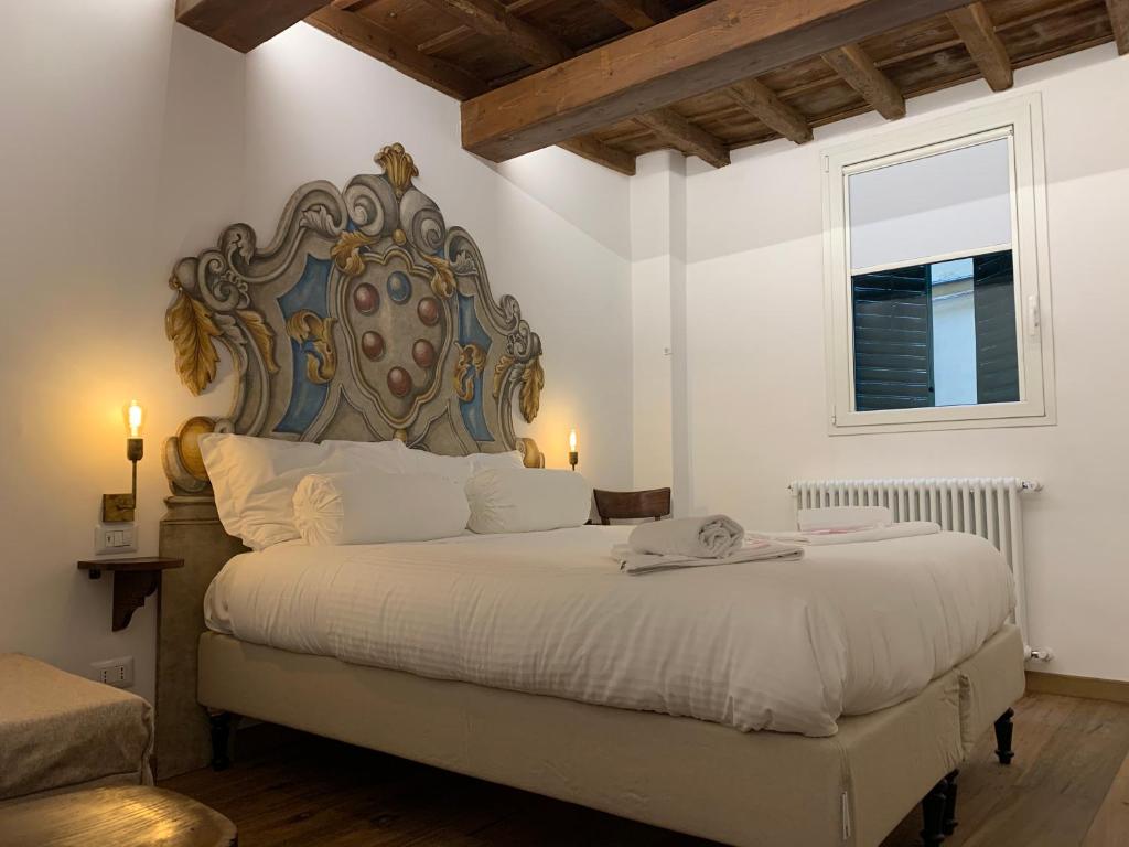 una camera da letto con un grande letto con una grande testiera di AI MAGAZZINI DEI MEDICI (casa con balcone) a Firenze