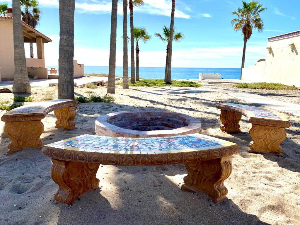 a stone bench sitting on the beach next to the ocean at Casita Blanca by FMI Rentals in Puerto Peñasco