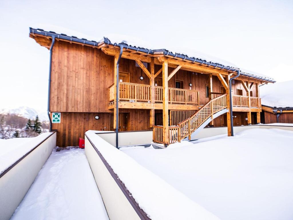a log cabin in the snow with a deck at Luxurious apartment near the pistes in family-friendly St François Longchamp in Saint-François-Longchamp