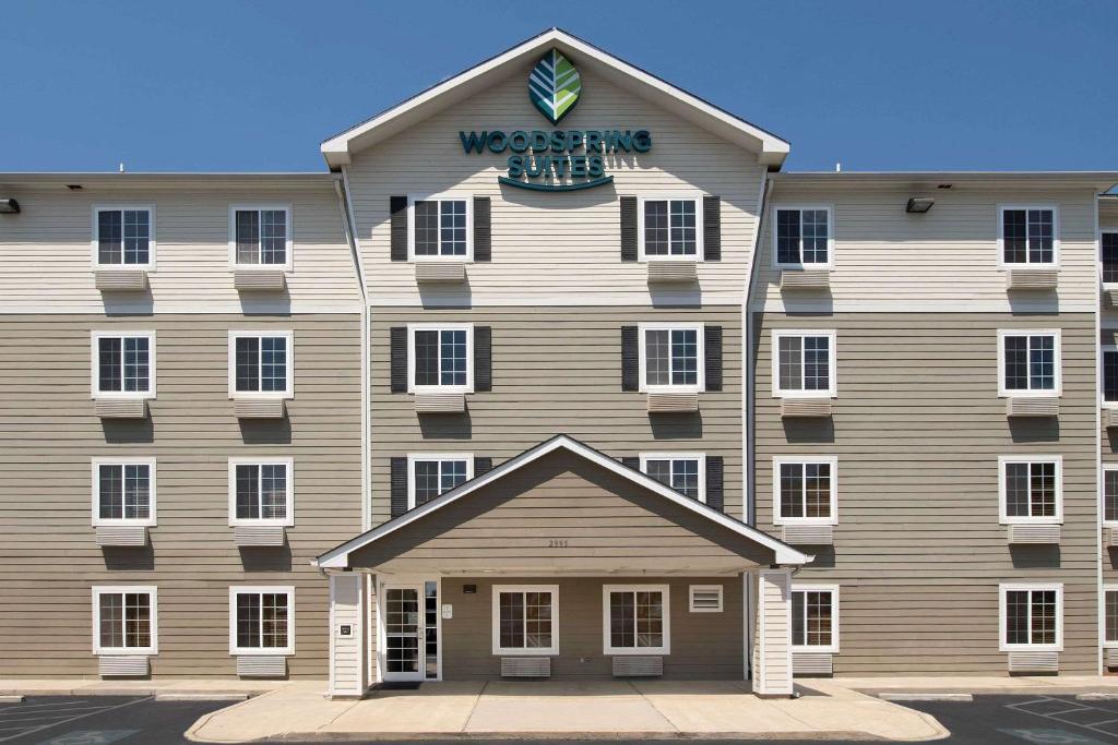 a building with a sign on the front of it at WoodSpring Suites Augusta Riverwatch in Augusta