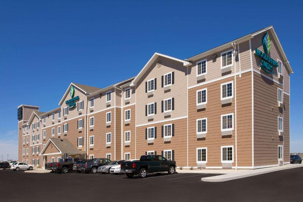 a large building with cars parked in a parking lot at WoodSpring Suites Hobbs in Air Base City