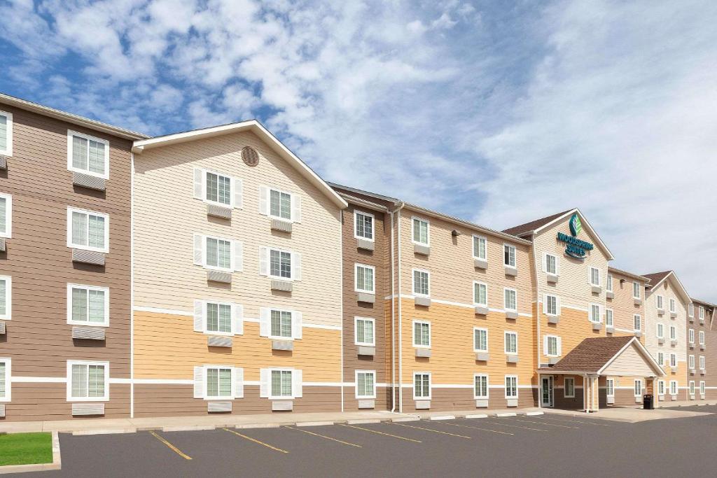 un gran edificio de apartamentos con aparcamiento en WoodSpring Suites Sioux Falls, en Sioux Falls