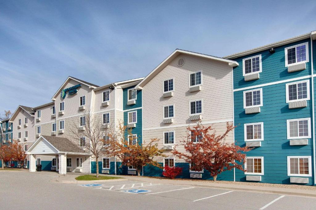 uma fila de edifícios de apartamentos com azul e branco em WoodSpring Suites Des Moines Pleasant Hill em Pleasant Hill