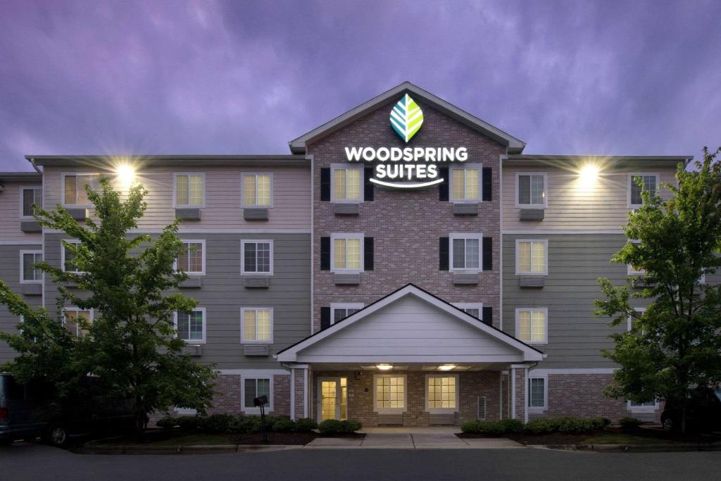 a building with a woodworking suites sign on it at WoodSpring Suites Raleigh Apex in Apex