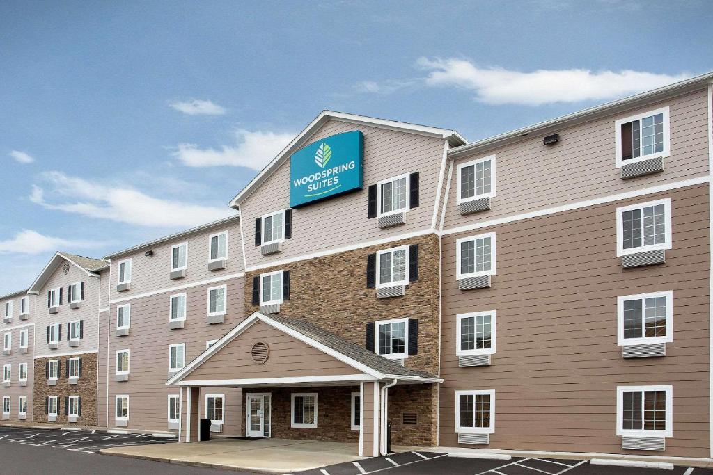 a large building with a sign on the side of it at WoodSpring Suites Columbus North I-270 in Columbus