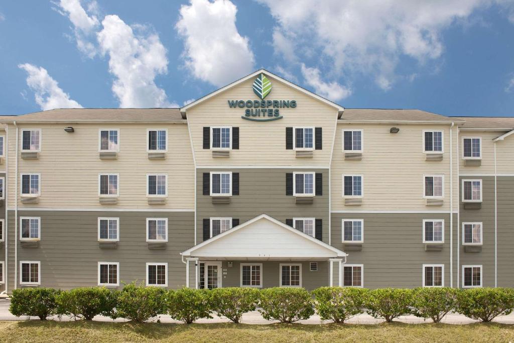 um grande edifício bronzeado com uma placa sobre ele em WoodSpring Suites Columbia Fort Jackson em Royal Pines Estates