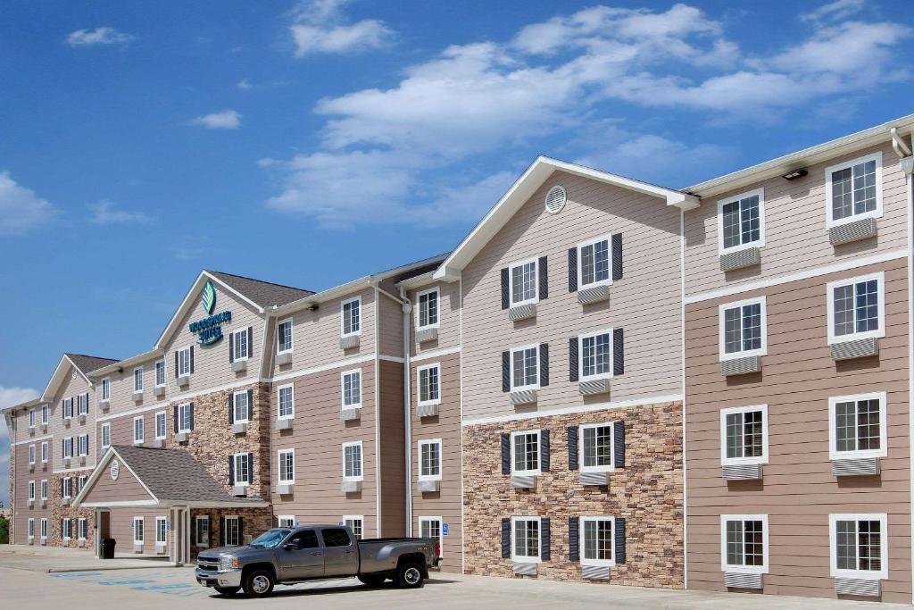 een vrachtwagen geparkeerd voor een groot gebouw bij WoodSpring Suites Lake Charles in Lake Charles