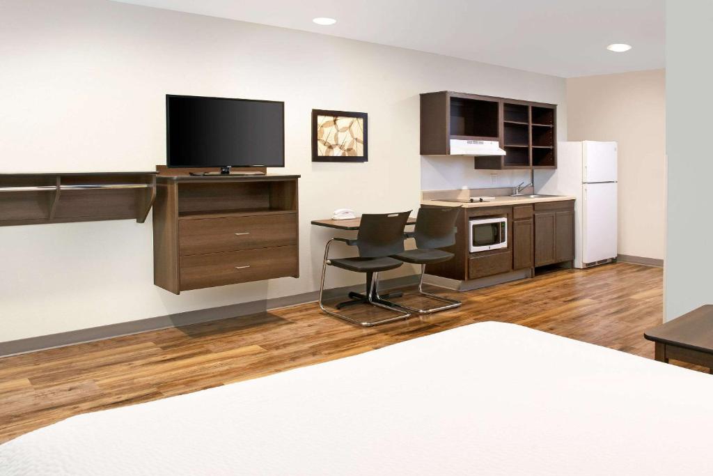 a room with a kitchen with a desk and a tv at WoodSpring Suites Nashville Airport in Nashville