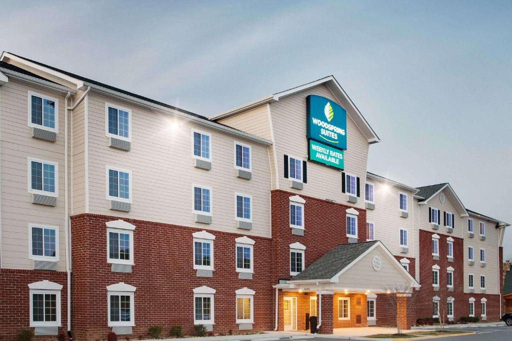 a large building with a sign on the side of it at WoodSpring Suites Fredericksburg in Fredericksburg
