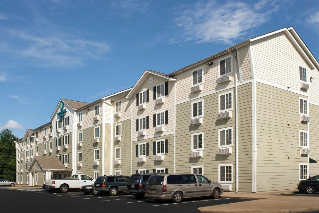 ein großes Gebäude mit Autos auf einem Parkplatz in der Unterkunft WoodSpring Suites Memphis Northeast in Memphis