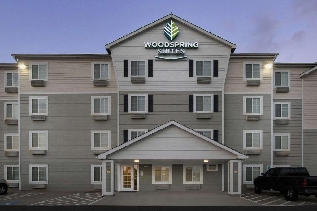 a building with a sign on the front of it at WoodSpring Suites Waco near University in Waco