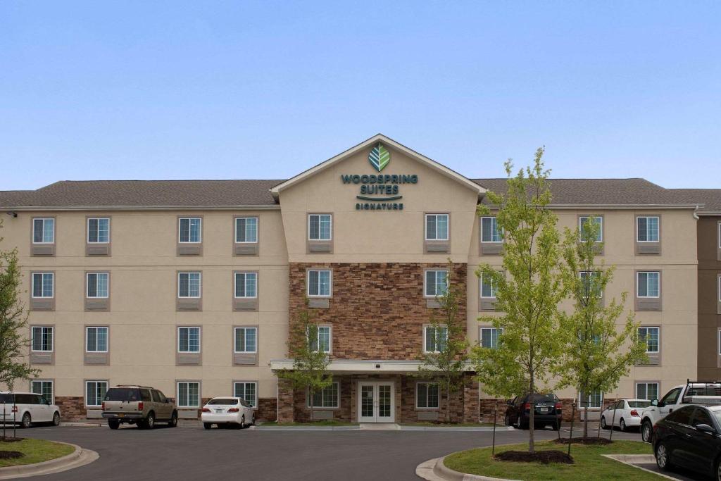 un edificio de hotel con coches aparcados en un aparcamiento en WoodSpring Suites Austin South Central I-35, en Austin