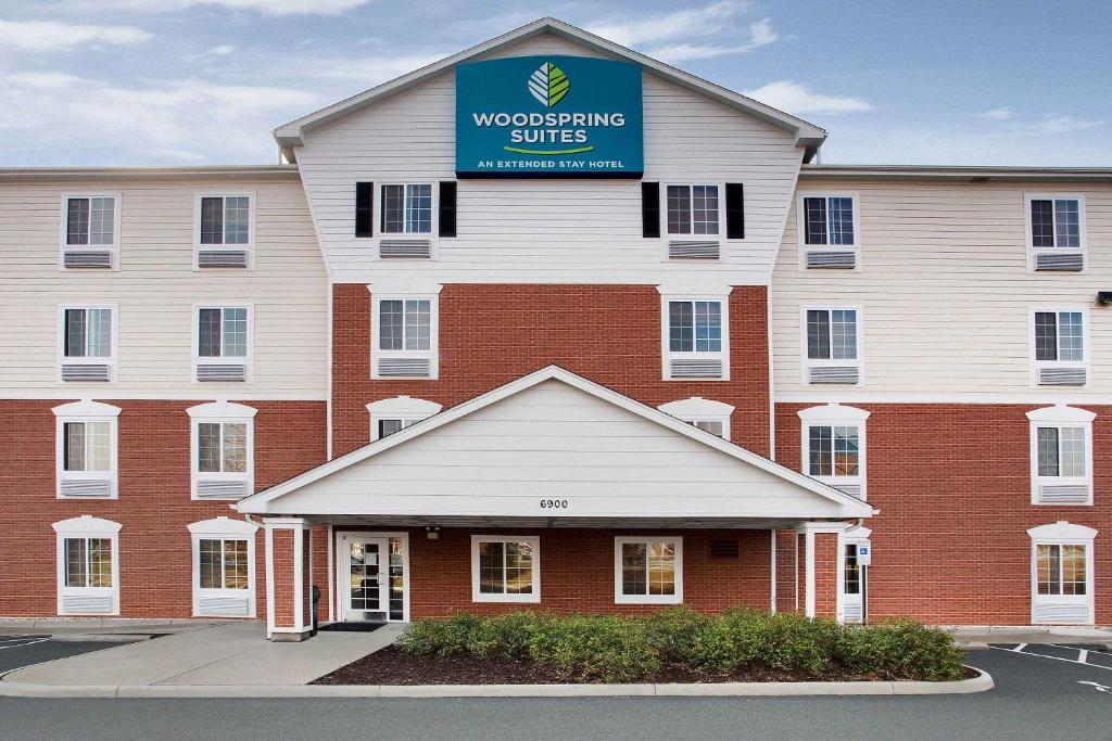 a large building with a sign on top of it at WoodSpring Suites Richmond West I-64 in Richmond