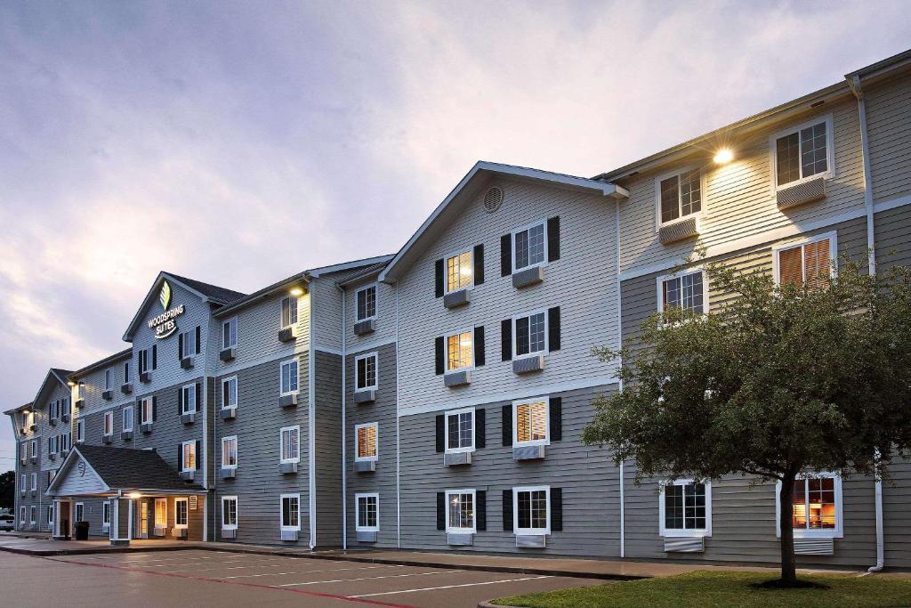 un gran edificio de apartamentos con luces encendidas en WoodSpring Suites Houston Willowbrook en Houston