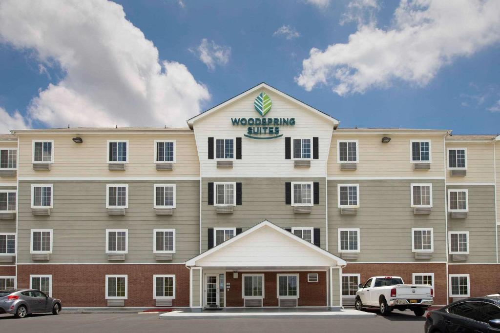 un gran edificio con un cartel encima en WoodSpring Suites San Antonio North Live Oak I-35, en San Antonio