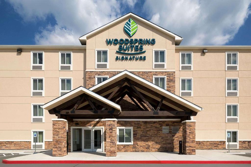 a rendering of the front of a wvering hotel at Woodspring Suites Houston IAH Airport in Humble
