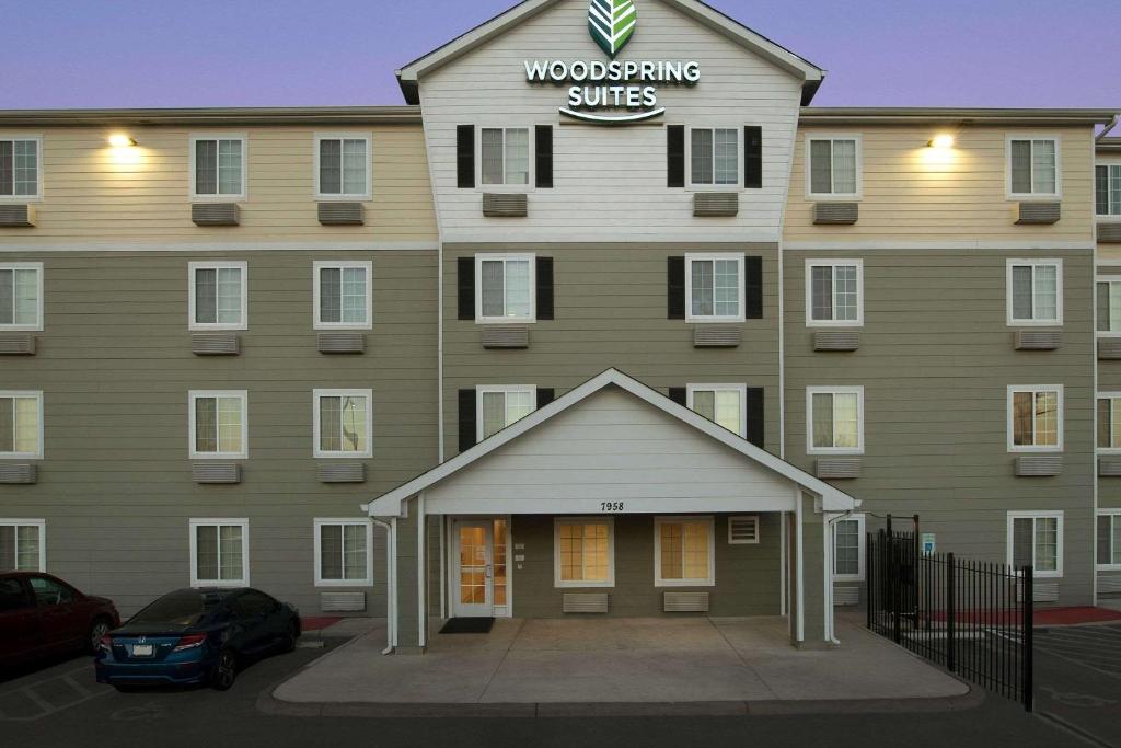 un edificio con un cartel que lee suites de carpintería en WoodSpring Suites San Antonio South en San Antonio