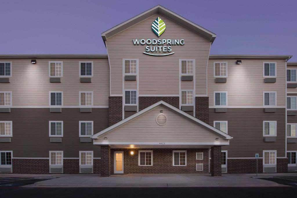 um edifício com um sinal de suites em madeira em WoodSpring Suites San Angelo em San Angelo