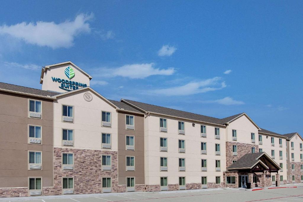 un bâtiment d'hôtel avec un panneau en haut dans l'établissement WoodSpring Suites Houston Northwest, à Houston