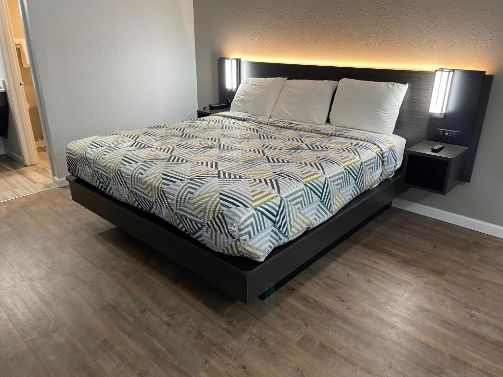 a bedroom with a large bed with a wooden floor at Studio 6 Vicksburg, MS- Downtown in Vicksburg