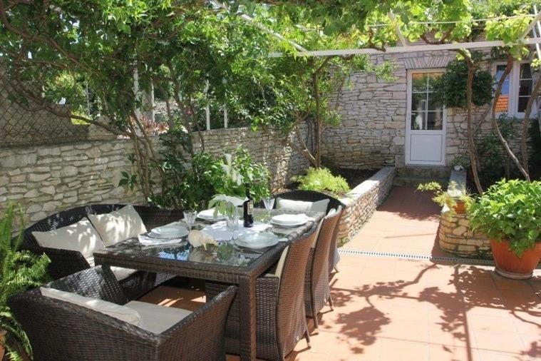 einen Tisch und Stühle im Terrassenbereich mit Tisch und Stühlen in der Unterkunft Holiday home Gita - peacefull in Sutivan