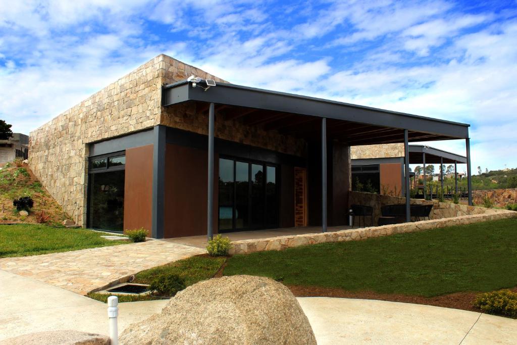 un edificio de piedra con techo negro en Parra del Valle Hotel Boutique, en Valle de Guadalupe