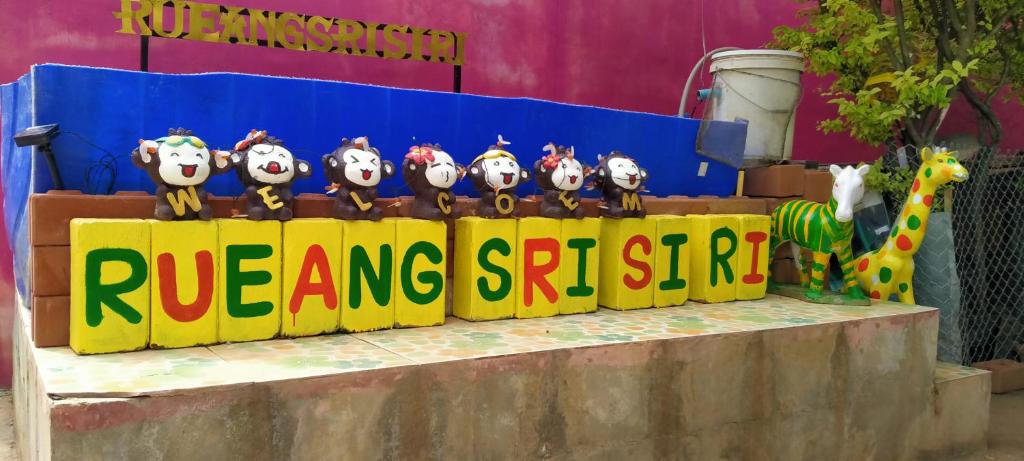 a group of owls sitting on top of a sign at RuengsriSiri Guesthouse in Sukhothai