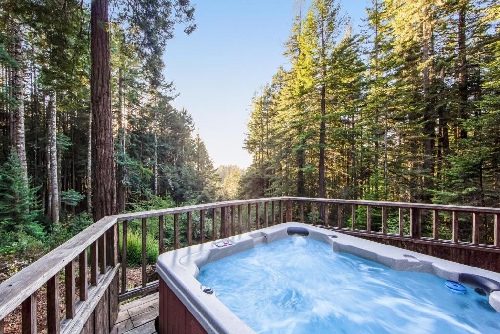 a hot tub on a deck in the woods at Sea Trees in Sea Ranch