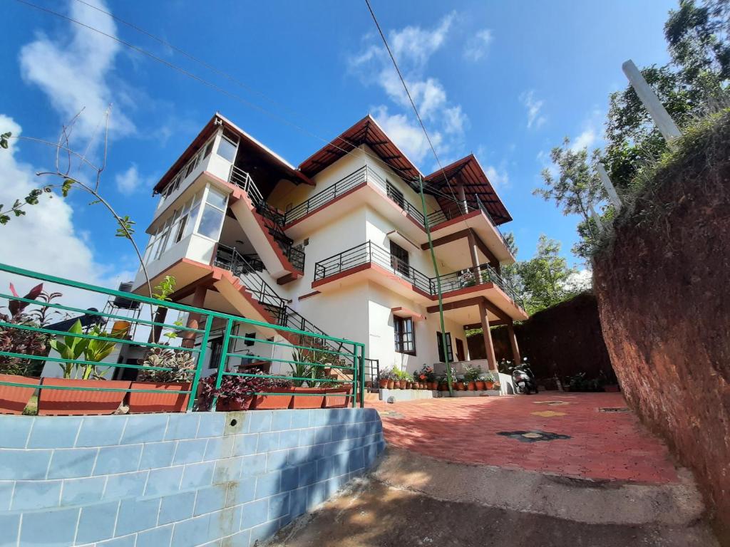 ein Haus mit einem Zaun davor in der Unterkunft Daisey Dee Homestay in Madikeri