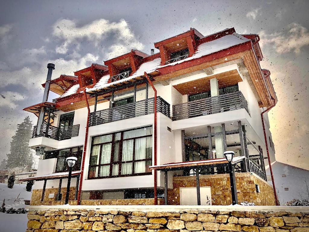 a large building with snow on the top of it at Pensiunea Favorit Ferice in Borsec