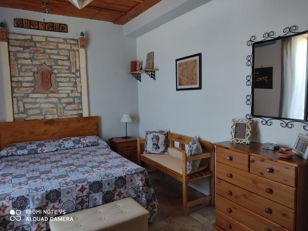 Schlafzimmer mit einem Bett, einer Kommode und einem Spiegel in der Unterkunft Torre Vallelunga in Trabia