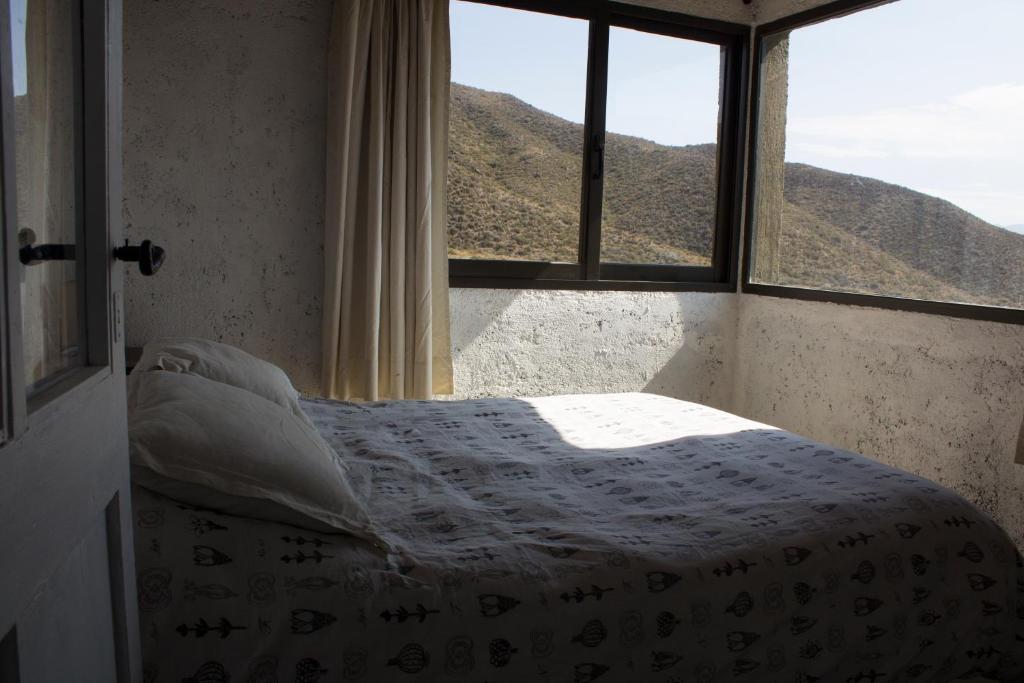 um quarto com uma cama e uma janela com montanhas em La casa de la paz em Potrerillos