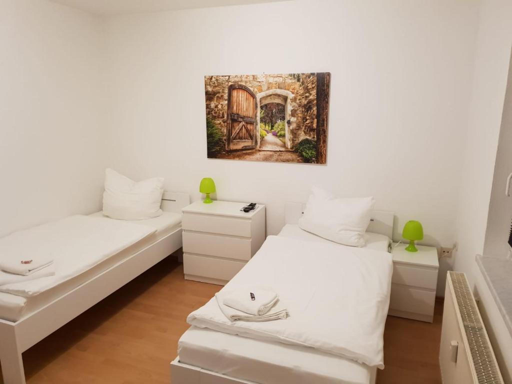 Zimmer mit 2 Betten und einer offenen Tür in der Unterkunft SchlafSchön Apartments+Monteurzimmer in Böhlen