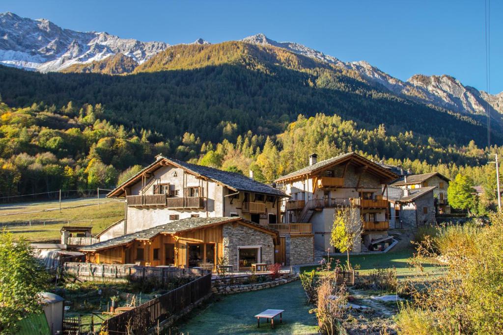 un groupe de bâtiments avec des montagnes en arrière-plan dans l'établissement Albergo Locanda Mistral, à Acceglio