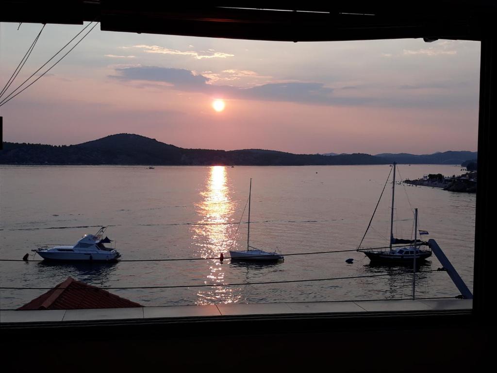 a group of boats in the water at sunset at Apartment Jela in Šibenik