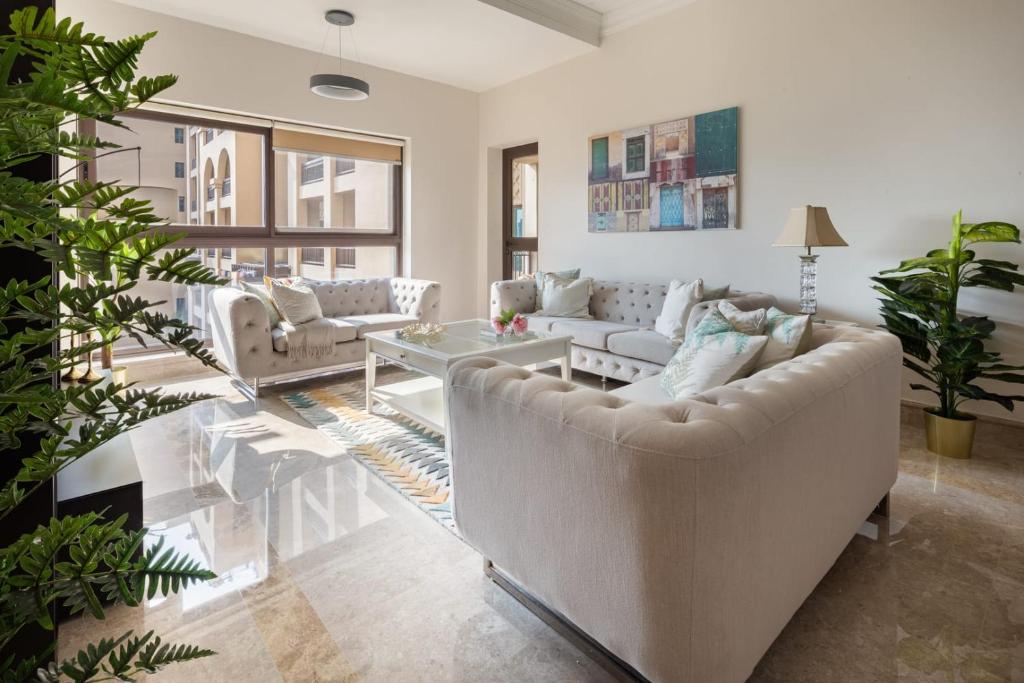 a living room with two couches and a table at Frank Porter - Fairmont Palm Residences in Dubai