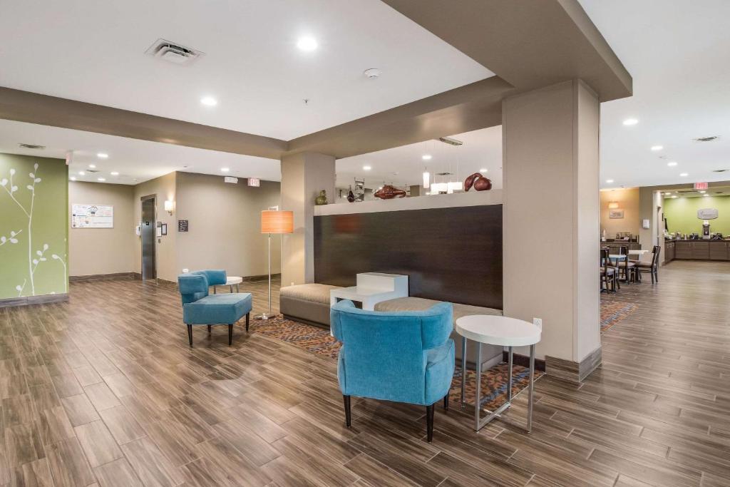 a lobby with blue chairs and a couch and tables at MainStay Suites in Union City