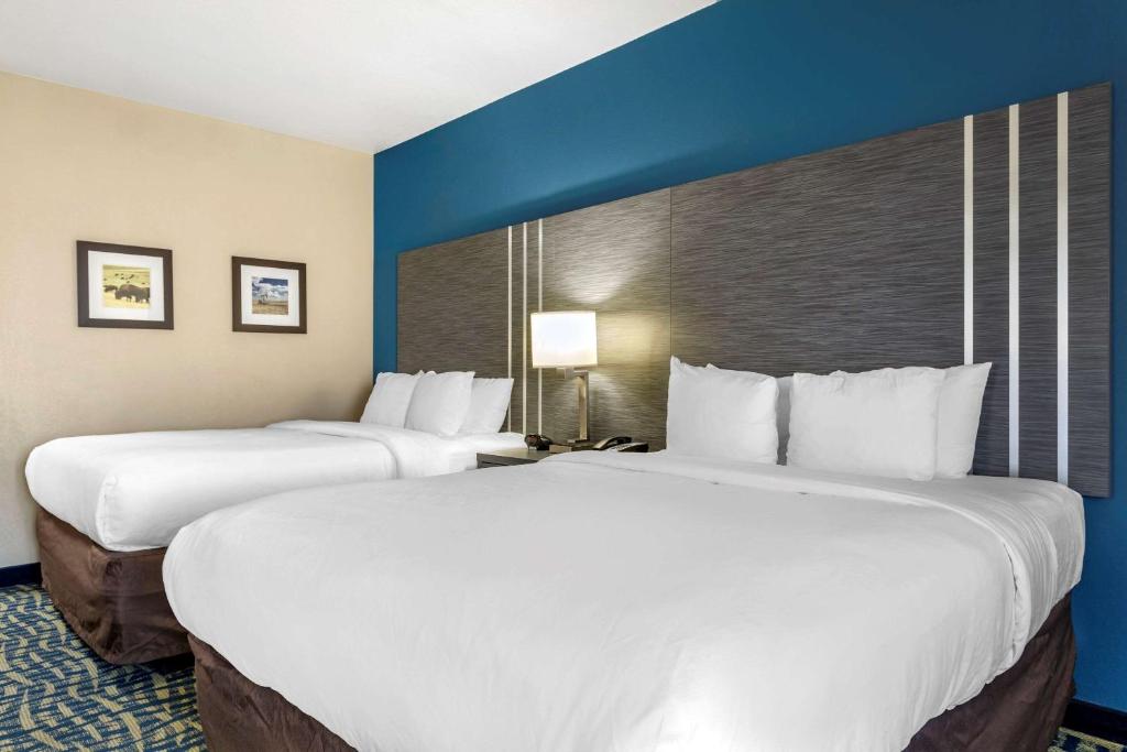 two beds in a hotel room with blue walls at Comfort Inn & Suites Pauls Valley - City Lake in Pauls Valley
