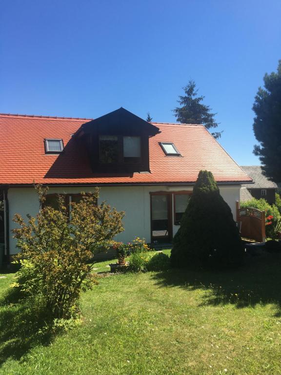 ein Haus mit einem roten Dach und einem Hof in der Unterkunft Haus Bergblick in Luftkurort Lückendorf